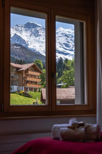 a window with a view of a snow covered mountain at Chalet Bella Vista 4 in Wengen