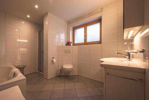 a white bathroom with a sink and a toilet at Chalet Bella Vista 4 in Wengen