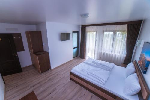 a bedroom with a bed and a large window at Bella Vista Turda in Turda
