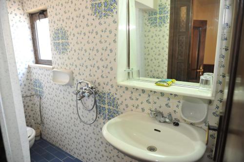 a bathroom with a sink and a mirror at Niki Hotel Apartments in Ialyssos