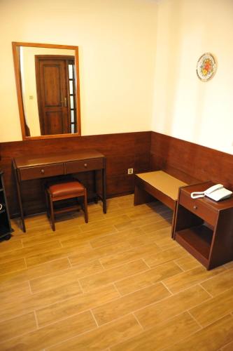 a room with a bench and a table and a mirror at Niki Hotel Apartments in Ialyssos