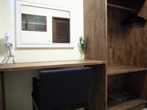 a desk with a window and a chair in a room at Bua House Poshtel in Chiang Mai
