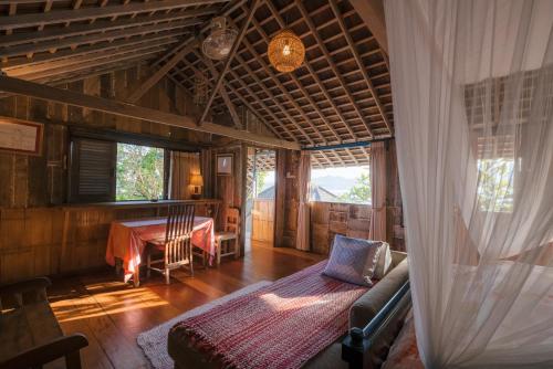 a room with a bed and a table in a house at Pondok Pisang Candidasa in Candidasa