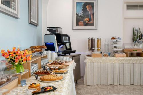 una panadería con pasteles y pasteles expuestos en los mostradores en Hotel Maria Serena en Rímini