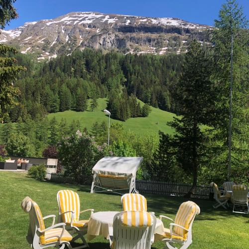 a patio with a table and chairs and a mountain at Hotel Regina Terme in Leukerbad