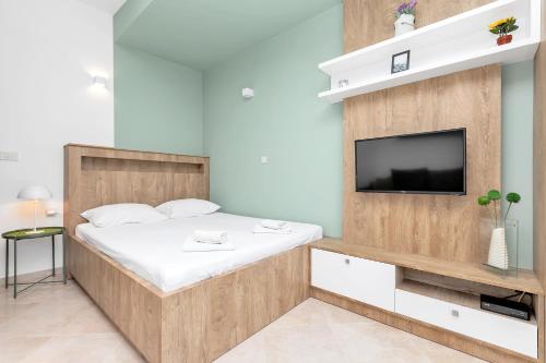 a small bedroom with a bed and a tv at Apartments Marilu in Kotor