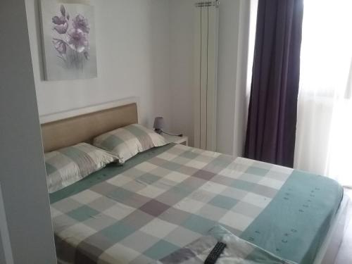 a bedroom with a bed with a checkered blanket at Flory`s Apartment Mamaia in Mamaia