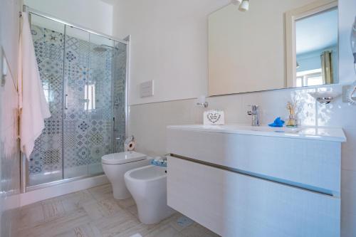 a white bathroom with a toilet and a shower at Bebcatia in Agropoli