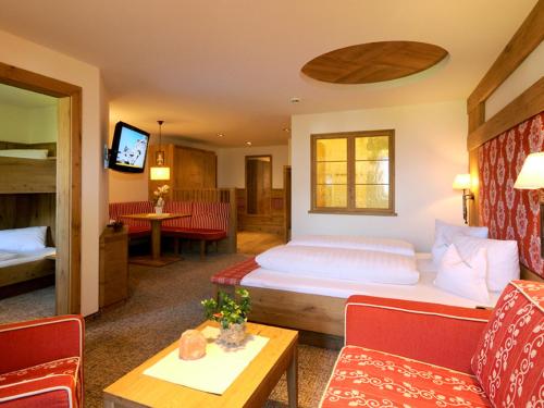 a hotel room with a bed and a living room at Hotel Pramstraller in Mayrhofen