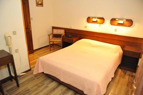 a bedroom with a bed and a desk and a chair at Niki Hotel Apartments in Ialyssos