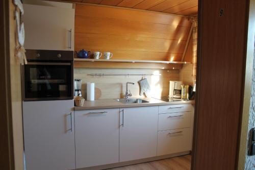 a kitchen with white cabinets and a sink at BELVEDERE Appart & Chalet - Ihr Zuhause auf Zeit am Edersee - Ihr Geschenk die GästeCard GrimmHeimat in Waldeck