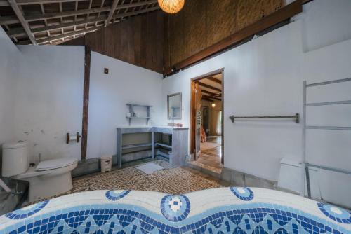 a bathroom with a toilet and a sink at Pondok Pisang Candidasa in Candidasa