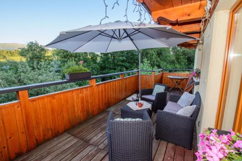 a patio with chairs and an umbrella on a deck at Willa Patryk in Zakopane