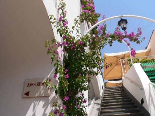 a staircase with flowers on the side of a building at Palazzo Ferraioli - Hotel & Wellness in Atrani