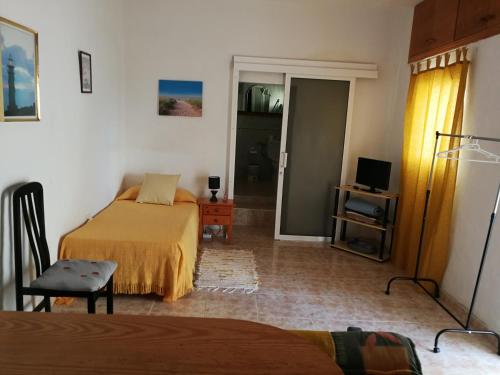1 dormitorio con 2 camas y puerta a una habitación en Vivienda Vacacional wiljis N3, en Tigaday
