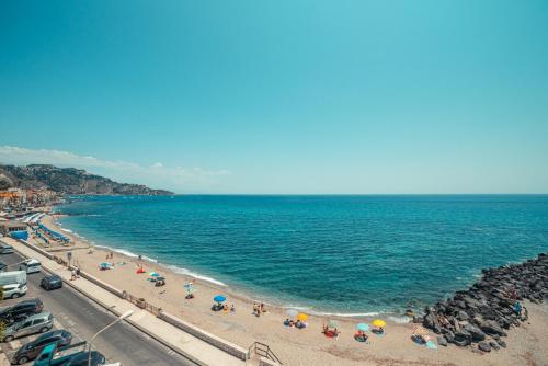a beach area with a row of beach chairs and umbrellas at Nautilus Hotel in Giardini Naxos