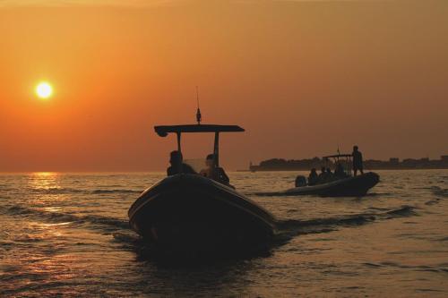 a group of people on a boat in the water at sunset at OrkulaBliss Apartments in Pašman