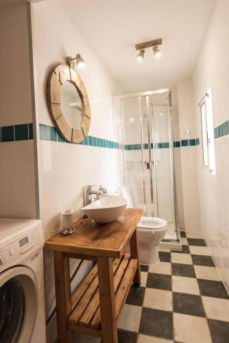 a bathroom with a sink and a washing machine at River Ebro Apartments in Móra d'Ebre