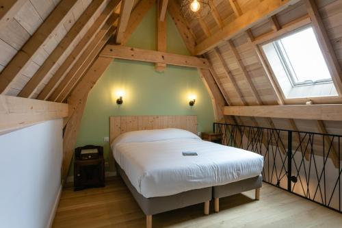 a bedroom with a bed in a attic at LE PETIT MOULIN in Martel