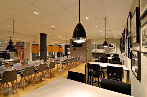 City Hotel Örebro في أوريبرو: مطعم بطاولات وكراسي في كفتريا