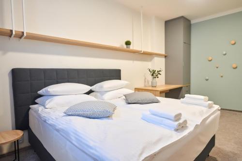 a large bed with white sheets and pillows on it at HONEST Smichov in Prague