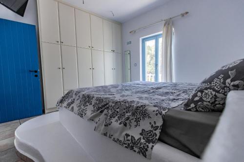 a bedroom with a bed and a couch and a window at Casa Bianca in Antiparos Town