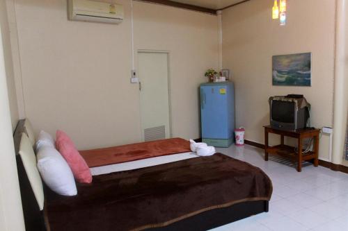 a bedroom with a bed and a small television at Ban Khun Rin Homestay in Amphawa