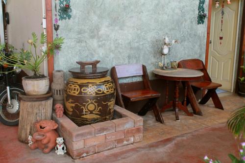a room with a table and chairs and a vase at Ban Khun Rin Homestay in Amphawa
