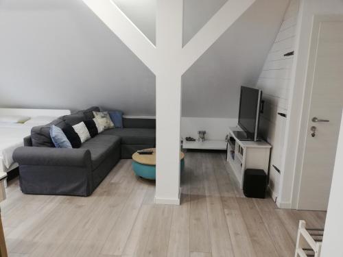 a living room with a couch and a cross on the wall at Studio apartman Zagreb Horvati in Rakov Potok