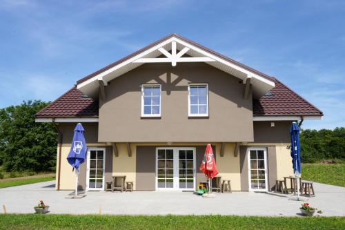 a house with two umbrellas in front of it at Karkle Beach Suites in Karklė
