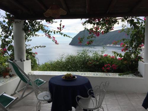 a table and chairs with a view of the water at Villa Vista Mare Mela in Lipari