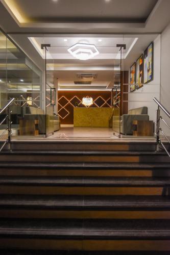 a lobby of a synagogue with stairs and chairs at Kensington Suites in Bengaluru