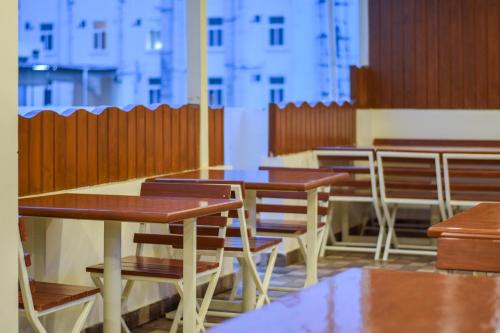 an empty restaurant with wooden tables and chairs at Kensington Suites in Bengaluru