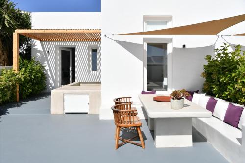a patio with a white table and a chair at Thiro Santorini in Fira