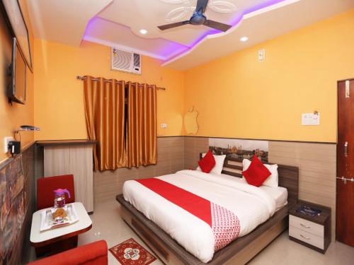 a bedroom with a large bed with red pillows at Hotel Bachchan Palace in Varanasi