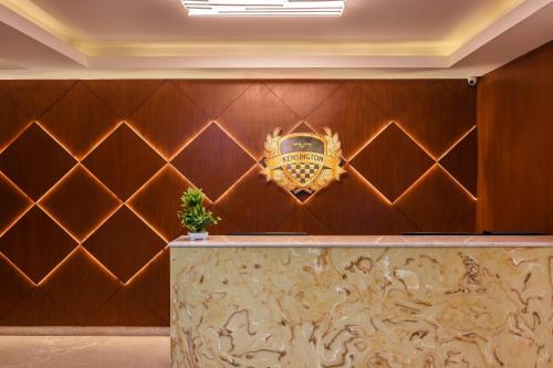a hotel lobby with a crest on the wall at Kensington Suites in Bengaluru