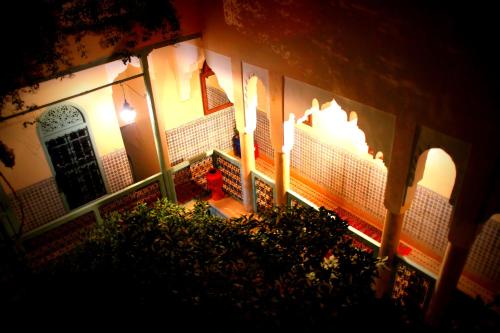 a house with two candles and a courtyard at night at Riad Al Nour in Marrakech