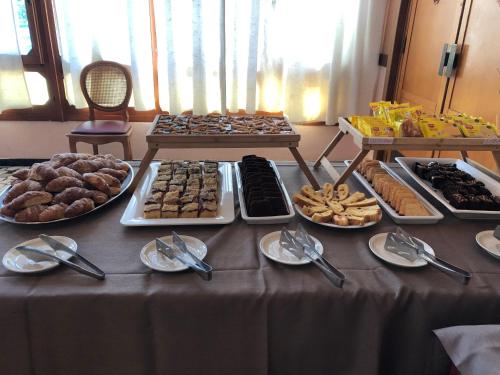 a table with many different types of food on it at Hotel AMALFI in Lido di Jesolo