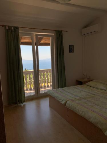 a bedroom with a bed and a large window at Marta in Matulji
