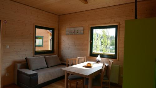 ein Wohnzimmer mit einem Sofa und einem Tisch in der Unterkunft Rozewska Bliza Domki Letniskowe in Jastrzębia Góra