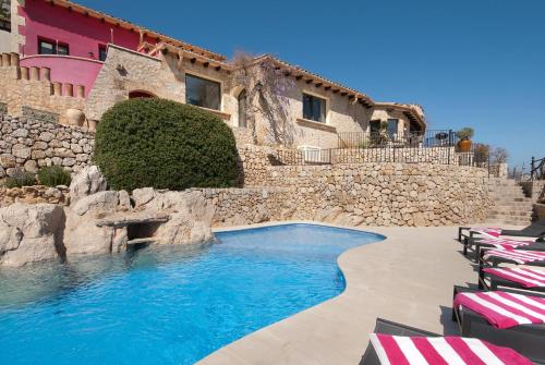a swimming pool in front of a building with chairs at SundanceMallorca in Port de Pollensa
