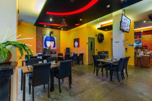 a dining room with tables and chairs in a restaurant at The Lantern Resorts Patong - SHA Extra Plus in Patong Beach