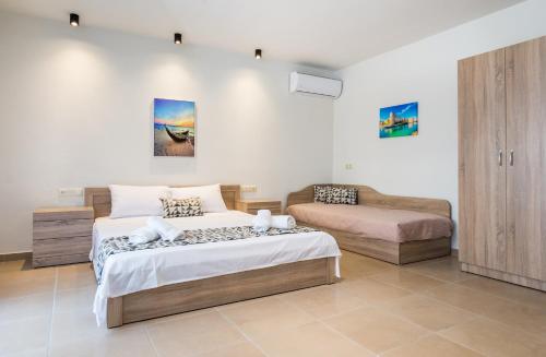 a bedroom with a bed and a couch at Studios & Apartments Elisabeta in Limenaria