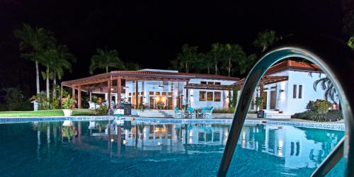 a swimming pool in front of a house at night at Amazing ocean views with many extras perks to enjoy in Cabarete