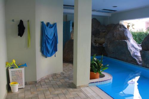 a indoor swimming pool with a large rock wall at Residence Le Vele in Cattolica
