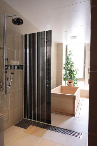 a bathroom with a shower and a tub and a sink at Kizashi The Suite Kyoto Gion in Kyoto