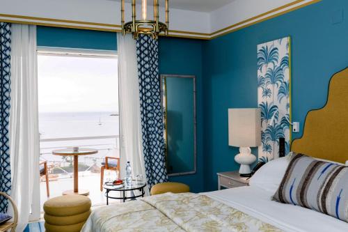 a bedroom with a bed and a view of the beach at The Albatroz Hotel in Cascais