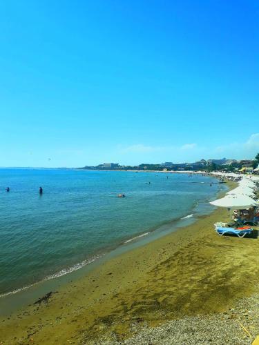 a beach with people swimming in the water at Side Tuana Garden Home in Side