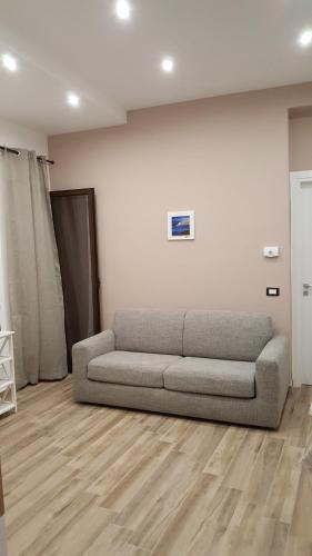 a couch in a living room with a wooden floor at da Matilda in Agrigento