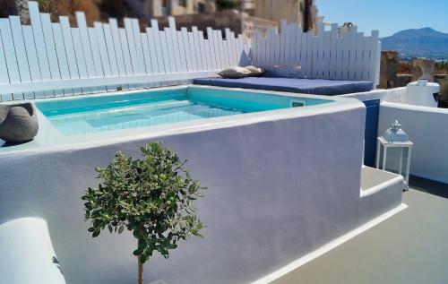 a swimming pool on the side of a white building at Santo Castello in Akrotiri